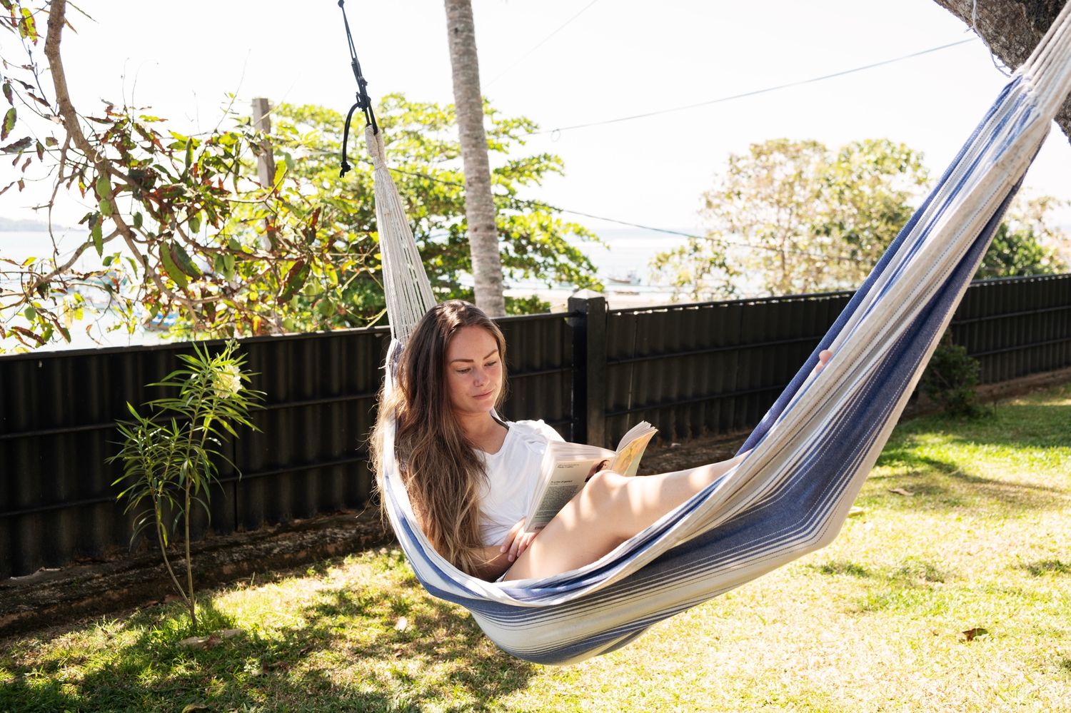 Reading in a hammock, the sea beyond the garden fence