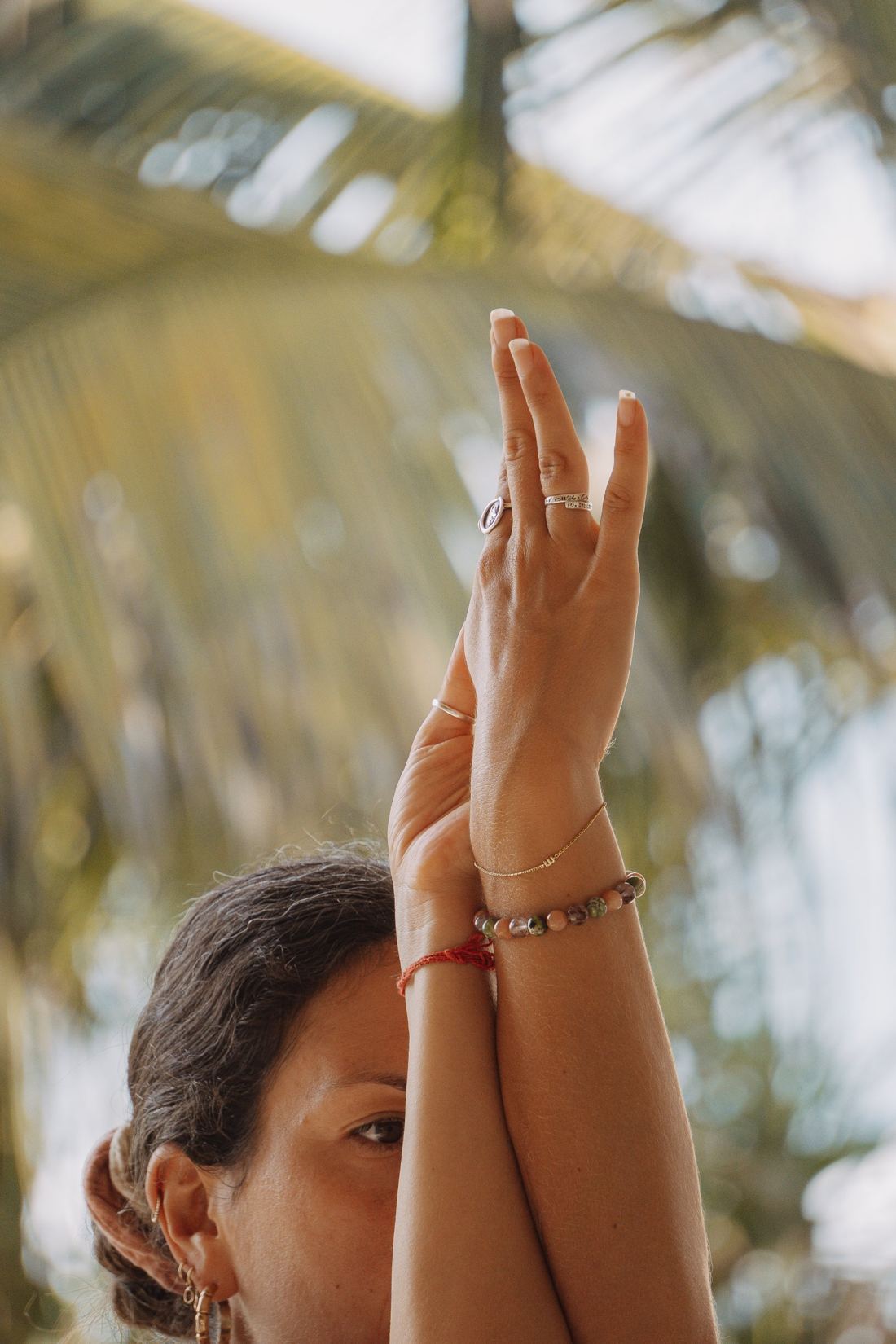Crossed forearms under a coconut palm
